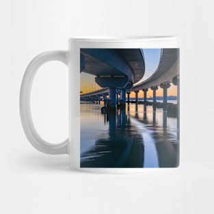 Curving lines and calm water under Tauranga Harbour Bridge at sunrise. Mug